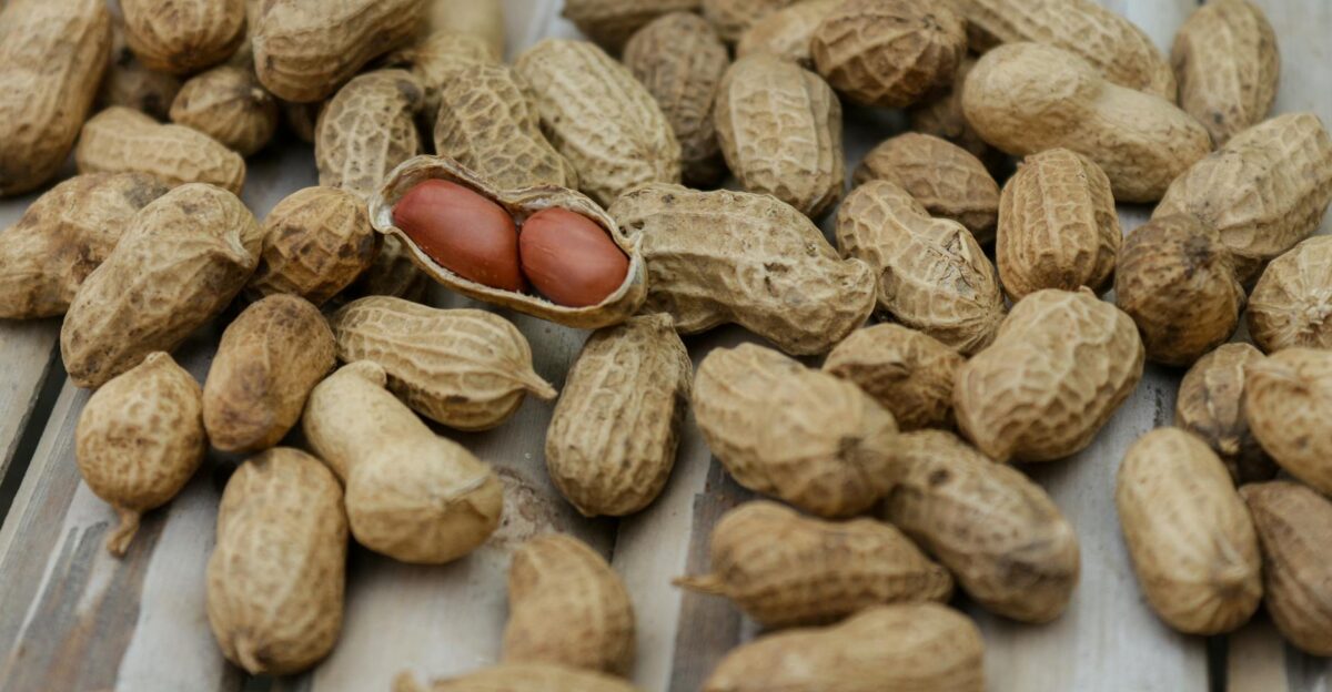 A detailed close-up of peanuts in their shells scattered on a wooden surface